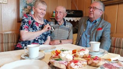 Bild: ubb
Eleonore und Anton Schöps (von links) zeigten bei ihrer Feier zur Eisernen Hochzeit ihrem Gast Toni Dutz auch das Hochzeitsfoto. Das Ehepaar konnte bei der Auswanderung von Rumänien nach Deutschland nicht viel mitnehmen. Aber die Familienfotos mussten natürlich mit.