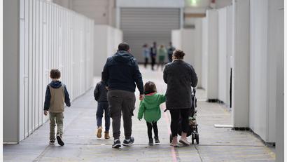 Archivbild: Boris Roessler/dpa
Eine Flüchtlingsfamilie geht durch die zu einer Massenunterkunft umfunktionierten Messehalle in Frankfurt.
