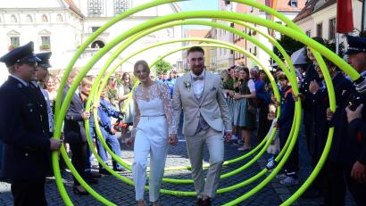 Bild: Kunz
Julia und Bastian Strehl schreiten gemeinsam durch ein Spalier aus Feuerwehrschläuchen.