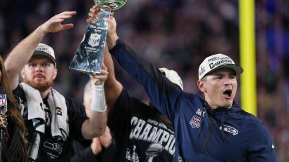 Bild: Matt Slocum/AP/dpa
Nur gemeinsam: Trainer MacDonald (rechts) reckt den Pokal mit seinen Spielern Darnold (links) und Walker in die Höhe.