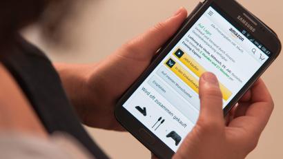 Symbolbild: Sebastian Gollnow/dpa
Eine Frau bedient die Smartphone-App des Onlinehändlers Amazon.