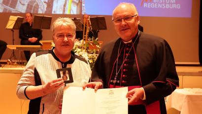 Bild: Pressestelle des Bistums Regensburg
Bischof Rudolf Voderholzer überreichte an Martina Mark die Wolfgangsmedaille mit entsprechender Urkunde.