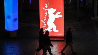 Bild: Britta Pedersen/dpa
Passanten gehen am Abend der Preisverleihung an einem Berlinale-Plakat vorbei.