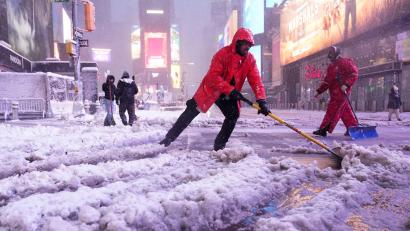 Bild: Seth Wenig/AP/dpa
Ein Arbeiter schaufelt Schnee auf dem Times Square in New York. Ein heftiger Schneesturm zieht über den Nordosten der USA hinweg.