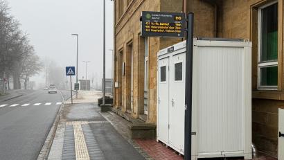 Bild: Stephan Huber
Der Bahnhof im Morgennebel: Direkt auf Höhe der Bushaltestelle gibt es jetzt zwei öffentliche Toiletten. Der Bauzaun um den weißen Container wurde abgebaut, das WC ist nun frei zugänglich – außer nachts und am Wochenende.