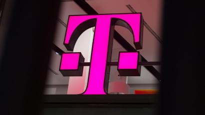 Bild: Rainer Jensen/dpa/dpa-tmn
Ein Telekom-Logo strahlt in Magenta - für den Konzern sind die Behördenpläne eine gute Nachricht.