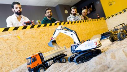 Bild: Moritz Frankenberg/dpa
Gründer Siymo Othman (links) steuert mit Freunden kleine Bagger, Radlader und Lastwagen in seinem neu eröffneten Bagger-Café. Es soll das erste dieser Art in Deutschland sein.