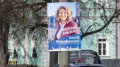 Bild: Armin Weigel/dpa
An einer Straße hängt ein Wahlplakat der CSU-Bürgermeisterkandidatin Astrid Freudenstein. In Bayern finden am 08.03.2026 Kommunalwahlen statt.