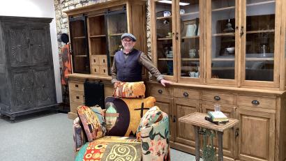 Bild: Monika Ziegeler
Der Geschäftsinhaber vor seinen Schränken. Links ein alter original indischer Schrank und zwei verschiedene Vitrinenschränke aus recyceltem, indonesischem Teakholz in geschliffener und gebürsteter Ausführung (links/rechts). Der Schaukelsessel ist von einem spanischen Partner, der nur ein Prozent Abfall produziert. Das Mittelelement des Beistelltisches ist von einem ehemaligen Metallgeländer