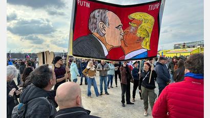 Bild: Michael Heitmann/dpa
Demonstranten halten bei einer Kundgebung des Bündnisses „Eine Million Augenblicke für Demokratie“ ein Banner, auf dem sich stilisiert US-Präsident Trump und Russlands Präsident Putin küssen.