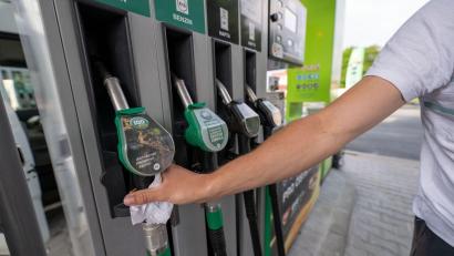 Archivbild: Pia Bayer/dpa
Ein Mann greift an einer Tankstelle in Tschechien zur Zapfpistole.