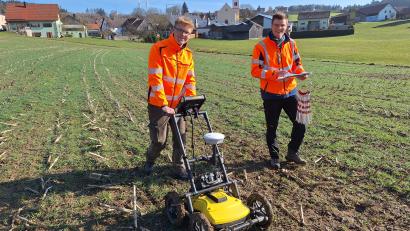 Bild: bl
Lukas König (links) schiebt das Bodenradar übers Feld, sein Studienkollege Jonas Müller setzt die großen Stecknadeln, die Fixpunkte auf dem Gelände markieren.