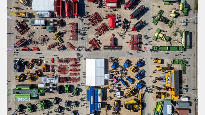 Bild: Jan Woitas/dpa
Eine Drohnenaufnahme zeigt Besucher, die bei der Landwirtschaftsmesse „agra 2026“ zwischen riesigen Landmaschinen und Traktoren gehen.