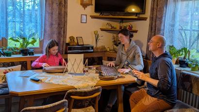 Bild: hdk
Thea, die Enkelin der betreuten Senioren, mit Marina Rischan beim Zitherspiel und BR-Reporter Tobias Föhrenbach.