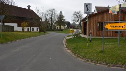 Bild: jr
Vom Multifunktionsgebäude (rechts) bis zum Ortsrand in Richtung Kriegermühle wollen die Hofteicher eine Begrenzung auf 30 Kilometer pro Stunde. Nach dem Ortsrand soll Tempo 50 gelten. Bürgermeister Johann Burger will die Polizei zu Rate ziehen, ehe eine Entscheidung fällt.