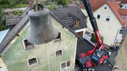 Bild: Alfons Götzfried
Die alte Glocke schwebt am Kranhaken aus dem Kirchturm heraus und über der Kirchgasse – eine Spezialoperation, die es so in Rosenberg lange nicht mehr zu sehen geben wird.