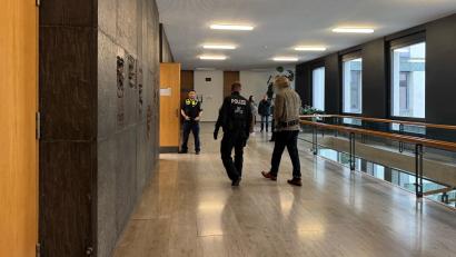 Bild: Stefanie Tretter
Der Angeklagte wird mit Hand- und Fußfesseln, verbunden über eine Bauchbinde, in den Sitzungssaal geführt.