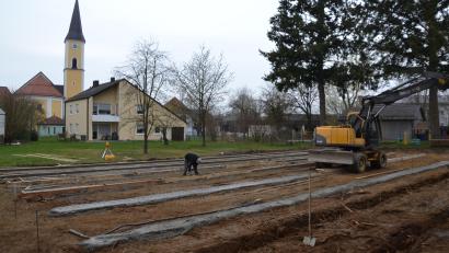 Bild: gi
Der Einbau der Fundamente für die Container-Übergangslösung während der Zeit des Kindergartenbaues läuft bereits. Im Hintergrund sind das Pfarramt, der Kindergarten und die Pfarrkirche zu sehen.