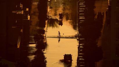 Bild: Uncredited/AP/dpa
Ein Junge überquert eine mit Regenwasser gefüllte Straße in Schardscha, Vereinigte Arabische Emirate.