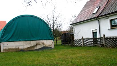 Archivbild: bkr
Zu nahe an der Grundstücksgrenze steht diese Rundbogenhalle. Sie ist ein Schwarzbau. Aus brandschutzrechtlichen Gründen durfte die Nachbarin ihren Wohnhausanbau bislang nicht verwirklichen. Diese Entscheidung des Gemeinderats hat nun das Landratsamt kritisiert.