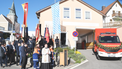 Bild: sche
Kaplan Marvin Schwedler, umrahmt von den Fahnen der teilnehmenden Feuerwehren, bei der Segnung des neuen Einsatzfahrzeuges der FFW Aschach.