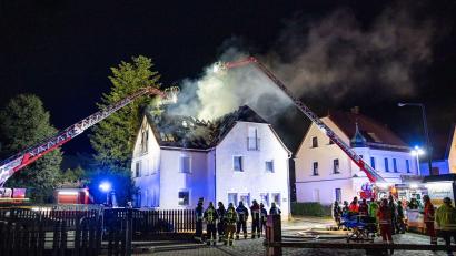 Bild: David Oßwald/NEWS5/dpa
Einsatzkräfte der Feuerwehr sind mit einer Drehleiter am Brand eines Dachstuhls in Nürnberg beschäftigt.