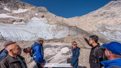 Bild: Michael Kappeler/dpa
Der Geograph Hagg - hier an der Zugspitze vor dem schmelzenden Gletscher - sieht einen Ausstieg aus dem Klimaziel 2040 kritisch. (Archivbild)