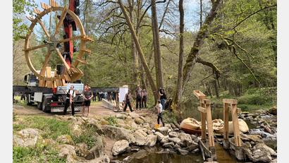 Bild: Gabi Schönberger
Das historische Wasserschöpfrad ist wieder an seinem angestammten Platz im Waldnaabtal. Von einem Lastwagen aus schwebte die rund zweieinhalb Tonnen schwere Konstruktion aus Eichenholz mit einem Durchmesser von fünf Metern durch die Luft. Sicher befestigt an einem Kran, den Zimmerermeister Antonio Schatzberger (am Lastwagen, rechts) bediente. Sein Vater Anton Schatzberger (links daneben) ist ebenfalls Zimmerermeister und packte mit an.