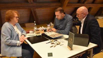 Bild: ubb
Gertraud Kollarik hat die Gelegenheit genutzt, den Aktionären Joshua Bamberger (hinten li.) und Ramon Bamberger aus dem Auktionshaus Miltenberg ihre Münzsammlung zu zeigen.