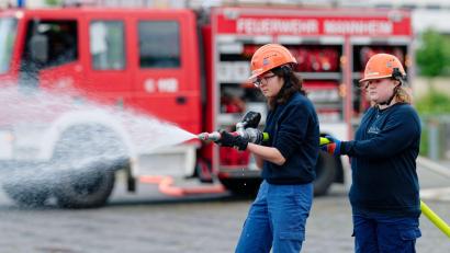 Bild: Uwe Anspach/dpa
Ilias (links) und Annabella, Mitglieder der Jugendfeuerwehr in Mannheim, halten bei einer Übung einen Feuerwehrschlauch in den Händen.