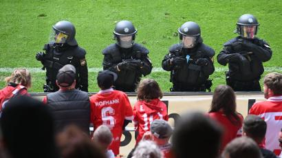 Symbolbild: Jens Niering/dpa
Polizeikräfte stehen vor dem Cottbuser Fanblock im Jahnstadion Regensburg.