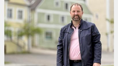 Bild: upl
Robert Jung ist seit Mai 2026 der neue Bürgermeister der Marktgemeinde Hohenburg. Im Hintergrund das ehemalige Wirtshaus, in dem das Naturparkzentrum Hirschwald eingerichtet werden soll.
