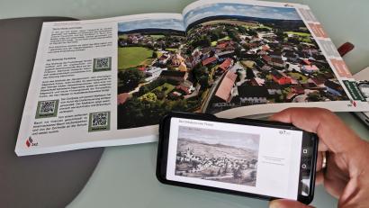 Bild: Portner
100 Jahre liegen zwischen diesen zwei Panoramabildern von Teunz, fotografiert vom gleichen Blickwinkel aus. Während die aktuellen Fotos in der Festschrift abgedruckt sind, können die historischen Aufnahmen per QR-Code am Handy heruntergeladen werden.