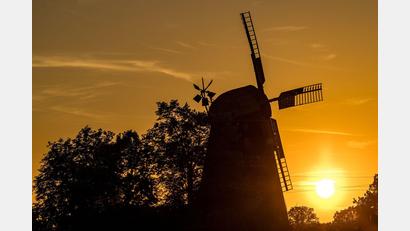 Bild: Frank Hammerschmidt/dpa
Die Sonne geht hinter der Turmholländermühle in Dörrwalde unter.