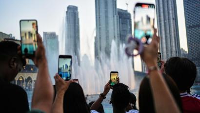 Bild: Fatima Shbair/AP/dpa
Eid al-Adha in Dubai: Besucher fotografieren den Brunnen vor der Skyline