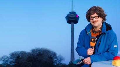 Bild: Ben Knabe/ZDF/dpa
Autor Chris Sommer in seiner Rolle als Reporter Peter-Stefan Thomas vor dem Kölner Fernsehturm - das „ZDF Magazin vor Ort: Die Colonius-Sprengung“ kommt am Freitag. (Handoutbild)