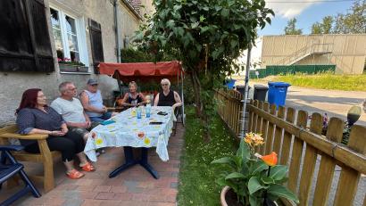 Bild: ck
Einige Anwohner des Containerdorfs (rechts im Hintergrund) in Neustadt/WN treffen sich im Vorgarten von Familie Mastalar. Die Modulanlage wird derzeit abgebaut. Die Geflüchteten sind bereits ausgezogen.
