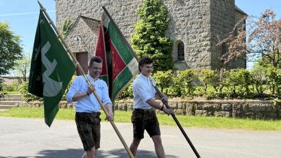 Bild: fvo
Thomas Schmid trägt das grüne KLJB - Banner und Jonas Feiler (rechts) die alte Lennesriether Burschenvereinsfahne vor die Albersriether Dorfkapelle.