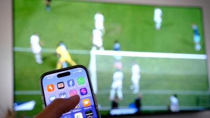 Symbolbild: Bernd Weißbrod/dpa
Nebenbei mal daddeln: Während das Fußballspiel läuft, schauen viele Zuschauer nebenbei aufs Handy.