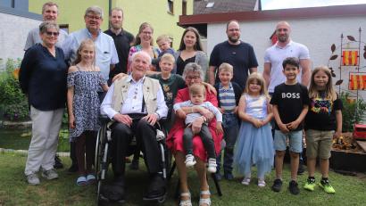 Bild: war
Alois Böhm (sitzend zusammen mit seiner Ehefrau Marga) an seinem 90. Geburtstag mit dem Großteil seiner Enkel und Urenkel. Gefeiert wurde mit der Großfamilie in einem eigens erstellten Zelt. Maria Smola (links) und Bürgermeister Martin Schregelmann (hinten Zweiter von links) gratulieren dem Jubilar im Namen des Seniorenkreises der katholischen Kirche und der Gemeinde.