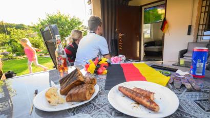Symbolbild: Julian Stratenschulte/dpa/dpa-tmn
Zusammen draußen im Garten Fußball schauen: Ist das auch mit den späten Anstoßzeiten der WM 2026 erlaubt?