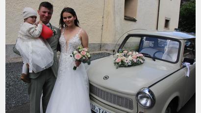 Bild: Konrad Rosner
Johanna und Jonas Zölch mit ihrem gemeinsamen Töchterchen Emma und ihrem Hochzeitsauto, einem Trabi.