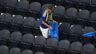Bild: Jessica Tobias/AP/dpa
Ein japanischer Fan räumt den Müll weg beim WM-Spiel im Dallas-Stadion.