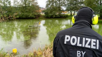 Archivbild: sbö
Ein Polizist trägt ein gelb-schwarzes Headset auf dem Kopf. Mit diesem kommuniziert er mit seinem Kollegen, der sich im Wasser befindet. Im Oktober wurde ein Weiher in Wernberg-Köblitz abgesucht.