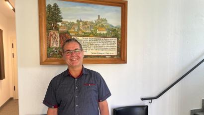 Bild: ihl
Der neue Thansteiner Bürgermeister, Michael Brandl, steht im Eingang des Bürgerhauses vor einer historischen Zeichnung Thansteins.