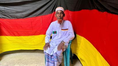 Bild: Nazrul Islam/dpa
Der 77-jährige bangladeschische Bauer Amjad Hossain posiert mit einer deutschen Fahne, die er zu Hause genäht hat.