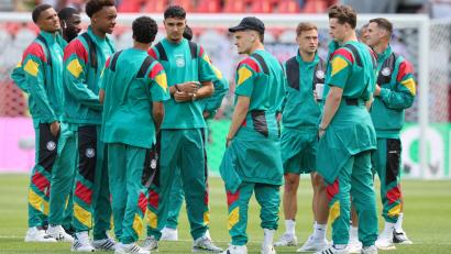 Bild: Jan Woitas/dpa
Die deutschen Spieler auf dem Stadionrasen nach der Ankunft.