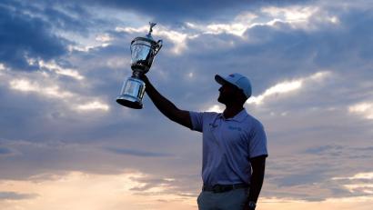 Bild: Seth Wenig/AP/dpa
Wyndham Clark präsentiert stolz die Trophäe.