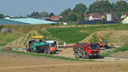 Bild: Elisabeth Dobmayer
Derzeit führen die Straßenbauer des Subunternehmens Firma Huber, Inhaber Josef Rappl GmbH & Co. KG die letzten Asphaltierungsarbeiten durch. Zum Baugebiet "Sommerwiesen" hin wurde ein Lärmschutzwall errichtet.