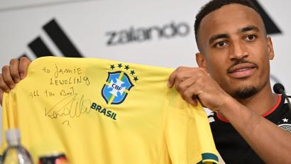 Bild: Federico Gambarini/dpa
Jamie Leweling zeigt das Brasilien-Trikot mit der Unterschrift von Ronaldo.